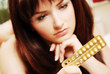 Photo: Young woman looking at her contraceptive pills Young woman looking at her contraceptive pills