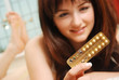 Photo: Happy girl looking at her contraceptive pills Happy girl looking at her contraceptive pills