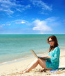 girl using a laptop near the sea