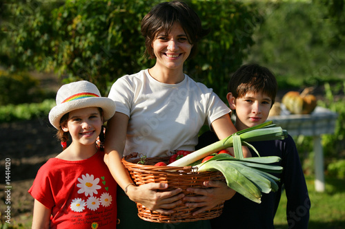 Photo: femme et enfants avec panier de légumes femme et enfants avec panier de légumes