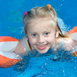 Young child is swimming in a pool