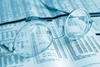 Eyeglasses on financial pages of a newspaper in blue tone