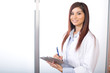 Woman doctor holding a chart in a modern office Woman doctor holding a chart in a modern office