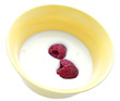 two raspberries in a yellow plate with milk two raspberries in a yellow plate with milk