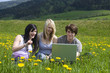 Jugendliche mit Laptop in freier Natur