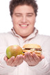 Foto: apple and hamburger in hands of a young chubby man, isolated apple and hamburger in hands of a young chubby man, isolated