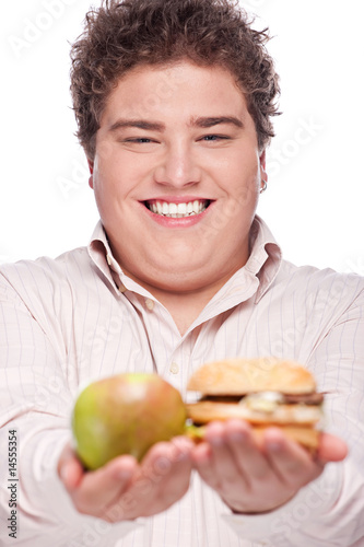 Photo: Young chubby man holding apple and hamburger, isolated on white Young chubby man holding apple and hamburger, isolated on white