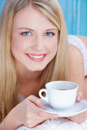 Foto: Pretty blond woman drinking coffee in bed Pretty blond woman drinking coffee in bed