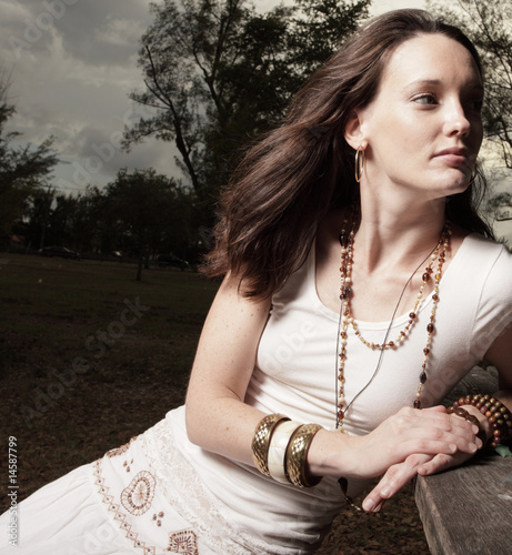 Photo: Beautiful woman sitting in the park Beautiful woman sitting in the park