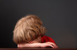 Young boy laying his head on his arms
