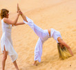 One girl supporting another in exercising