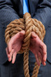 Businessman hands tied up with rope