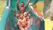 Famiglia si diverte con lo scivolo in piscina