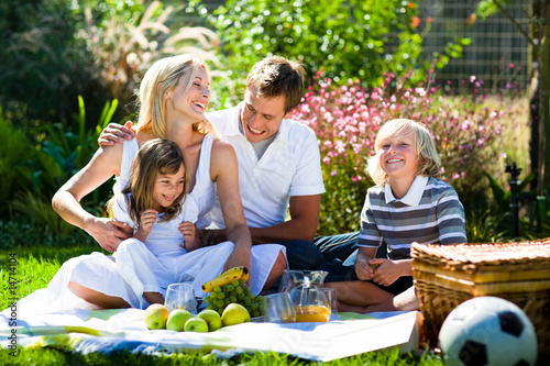 Photo: Happy family playing together in a picnic Happy family playing together in a picnic
