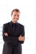 Handsome smiling businessman with folded arms