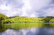 Lake, reflections of clouds. Forest and water-meadow in the dist