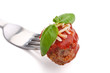 meatball with sauce, cheese and basil on a fork