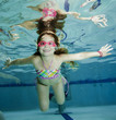 Happy little girl underwater in swimming pool