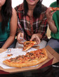 Group of people sitting and eating pizza