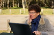 Senior woman using laptop outside