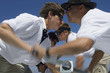 Sailors operating windlass on yacht, side view