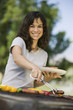 Woman Grilling Food at Park, portrait.