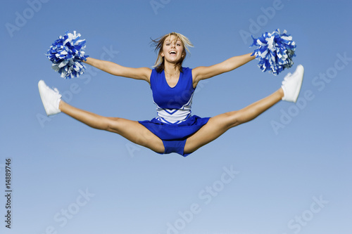 Photo: Smiling Cheerleader jumping in mid-air, portrait Smiling Cheerleader jumping in mid-air, portrait