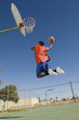 Basketball player, mid-air, dunking ball, side view