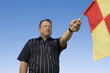 Soccer referee holding out penalty flag, portrait