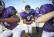 Football player running behind linemen on field