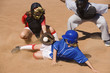 Softball player sliding into home plate