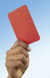 Soccer referee holding up red card, close-up on hand