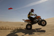 Quad bike rider doing wheelie in desert, side view