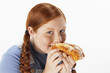 Overweight girl 13-15 eating doughnut, portrait