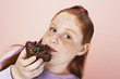 Overweight girl 13-15 Eating brownie, portrait, close-up