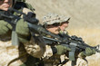 Soldiers aiming rifles in field