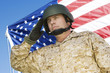 Soldier saluting in front of United States flag, portrait