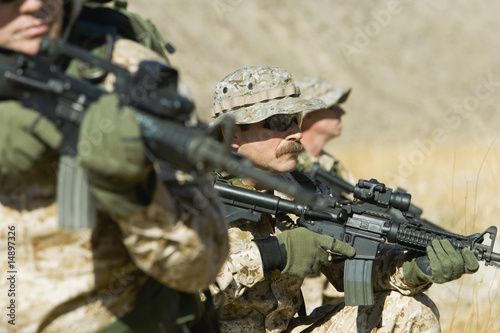 Photo: Soldiers aiming rifles in field Soldiers aiming rifles in field
