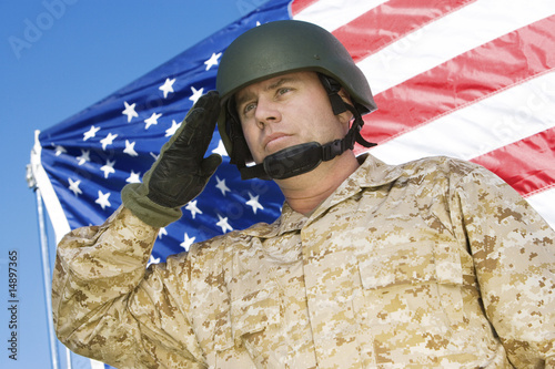 Photo: Soldier saluting in front of United States flag, portrait Soldier saluting in front of United States flag, portrait