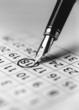 Tip of fountain pen marking date in calendar, b&w, close-up