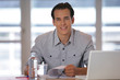 Portrait d'un homme souriant assis à un bureau Portrait d'un homme souriant assis à un bureau