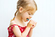 Cute little girl learning to brush her teeth