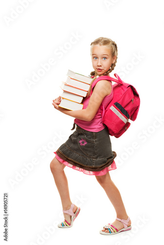 Happy litthe schoolgirl with a stack of heavy books