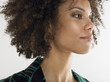 Woman with curly hair, head and shoulders in studio