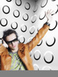 Photo: Man wearing headphones and sunglasses, blurred motion, in front of spotty wall Man wearing headphones and sunglasses, blurred motion, in front of spotty wall