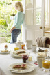 Woman With Tea standing in doorway, hand on hip, After Breakfast