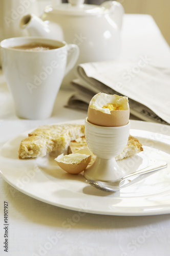 Photo: Half-Eaten Hard-Boiled Egg on dining room table, With Tea Half-Eaten Hard-Boiled Egg on dining room table, With Tea