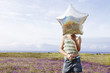 Little Girl Holding a Balloon in front of face in field of flowers