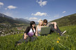 Foto: Junge Leute mit Laptop in Blumenwiese / Hintergrund Schladming Junge Leute mit Laptop in Blumenwiese / Hintergrund Schladming