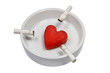 Cigarette stubs and a heart in a white ash-tray